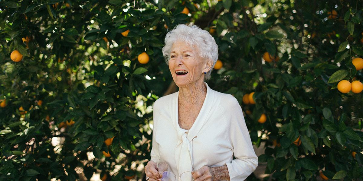 Elayne Lohr in front of multiple orange trees