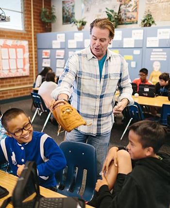 Grey McFall teaching students with a baseball glove on